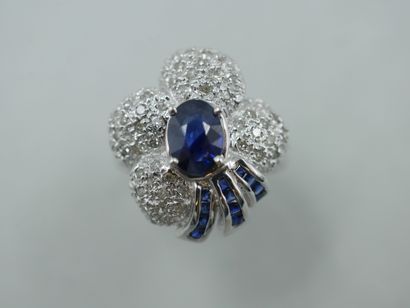 null An 18k white gold flower ring set with an oval sapphire of about 1ct in a diamond...