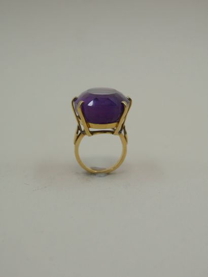 null An 18k yellow gold ring with an oval facetted amethyst weighing 32cts. PB :...