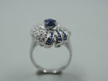 null An 18k white gold flower ring set with an oval sapphire of about 1ct in a diamond...