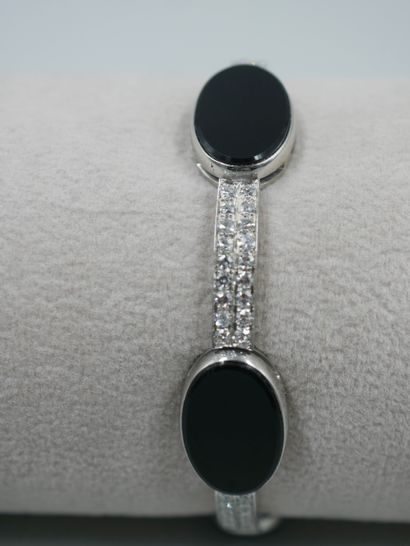 null 
Bracelet semi-rigide en or blanc 18k agrémenté de plaques d'onyx ovales alternées...