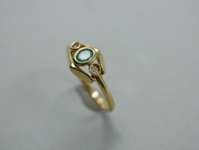 null An 18k yellow gold ring with an oval emerald and two diamonds on an openwork...