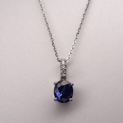 18K white gold pendant set with an oval sapphire...