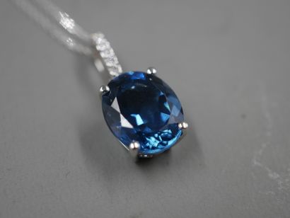 null 18k white gold pendant set with an oval "London Blue" topaz of about 6cts. Diamond-paved...
