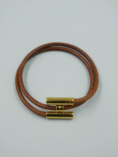 null HERMES Paris. Bracelet "Tournis" en cuir naturel marron et métal doré. Signé....