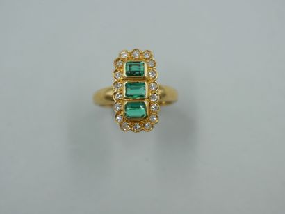 null An 18k yellow gold marquise ring with a rectangular bezel set with three emerald-cut...