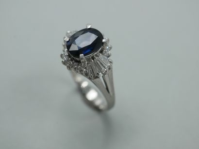 null A platinum skirt ring set with a 2ct oval sapphire set with baguette and brilliant-cut...