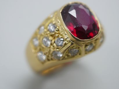 null 18k yellow gold signet ring centered on a red stone in a diamond-paved setting....
