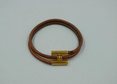 null HERMES Paris. Bracelet "Tournis" en cuir naturel et métal doré. Signé. Etat...