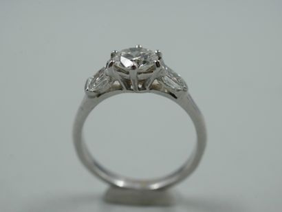 null Bague solitaire en or gris 18k ornée d'un diamant 0,75cts épaulé de deux diamants...