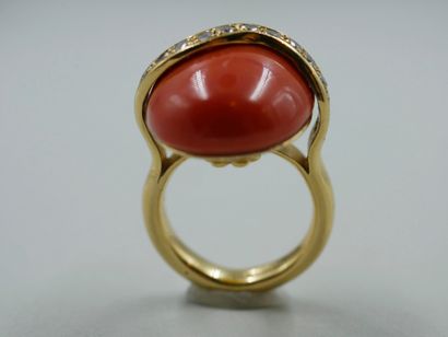 null Bague en or jaune 18k surmontée d'un cabochon de corail traversée par une ligne...