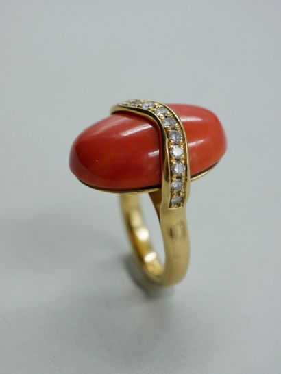 null Bague en or jaune 18k surmontée d'un cabochon de corail traversée par une ligne...