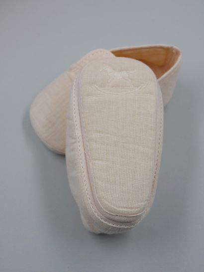 null HERMES Paris. 

Pair of little baby booties, in pink fabric, the sole embroidered...