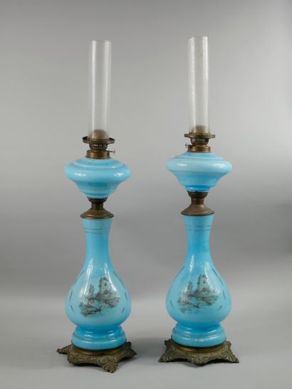 null A pair of blue opaline oil lamps with mill decoration.

Resting on a gilt bronze...