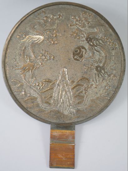 null JAPAN. 

Bronze mirror decorated with facing dragons. Handle covered with straw....
