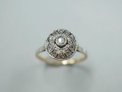 null 
An 18k yellow gold and platinum Art Deco ring, the round openwork bezel decorated...