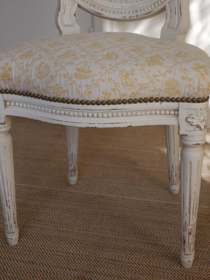 null A molded and white lacquered wood cabriolet chair decorated with a frieze of...