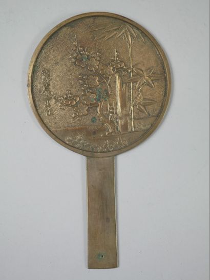 null JAPAN. 

Bronze mirror decorated with bamboos under a cherry tree in bloom....
