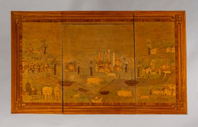 null A veneer chest of drawers inlaid with country scenes and landscapes with villages,...