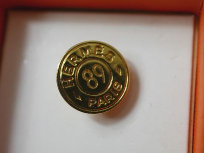 null HERMES Paris.

Circular pin in gilded metal with the number 89 in the center....