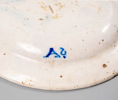 null White earthenware dish decorated with a bird in dominant blue and green surrounded...