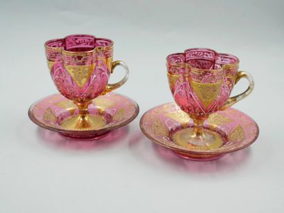 null Pair of red glass cups with gilded decoration of interlacing, with saucers.