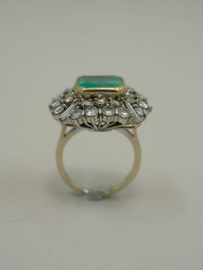 null 18k white gold ring surmounted by a 6cts emerald in a double setting of brilliant-cut...