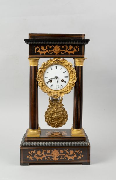 null 
Portico clock decorated with leafy interlacing on a darker wood background....