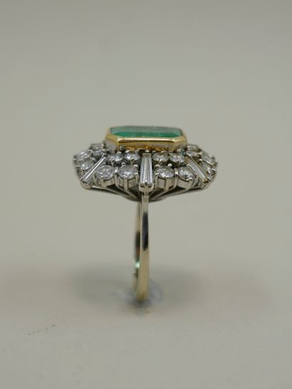 null 18k white gold ring surmounted by a 6cts emerald in a double setting of brilliant-cut...