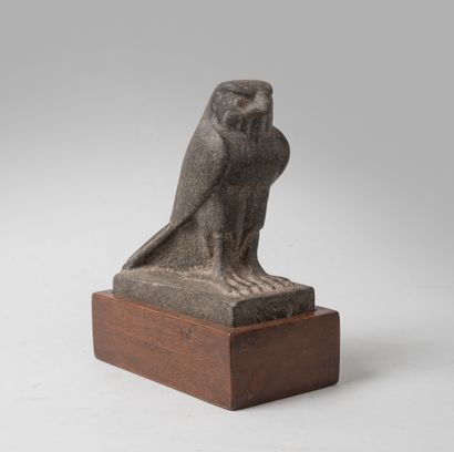 null Sculpture representing the falcon god Horus in black stone. 

Wooden base. 

Modern...