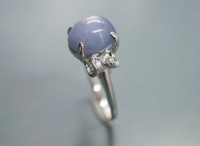 null 18k white gold ring set with a sapphire cabochon surrounded by diamonds in a...