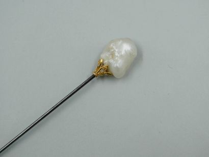 null Natural freshwater pearl of baroque shape held by a pink gold and diamond setting...