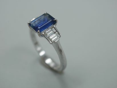 null Art Deco style ring in 18k white gold set with an emerald-cut sapphire of about...