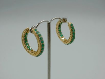 null Pair of 18k yellow gold hoop earrings set with emeralds in a diamond setting....