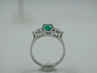 null 18k white gold ring centered on a 1ct oval emerald with flower motifs set with...