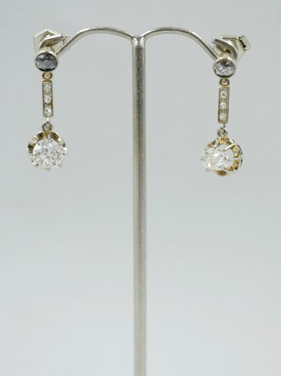 null Pair of 18k white gold sleepers adorned with round and oval half-cut diamonds...