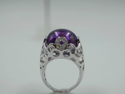 null 18k white gold ring surmounted by an amethyst cabochon in an openwork bezel...