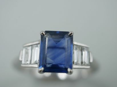 null Art Deco style ring in 18k white gold set with an emerald-cut sapphire of about...