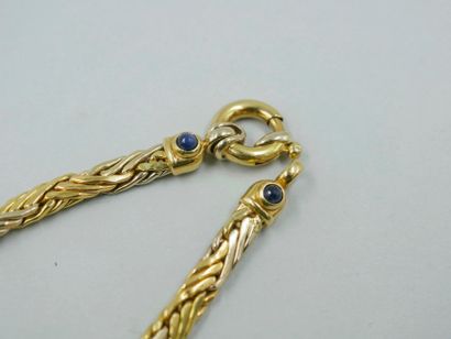 null Necklace in 18k yellow gold, the clasp surrounded by two cabochons of blue stones....