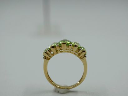 null Band ring in 18k yellow gold, decorated with oval peridots in fall punctuated...