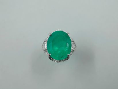 null Platinum ring set with a large oval Colombian emerald of about 10 cts., set...