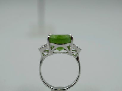 null 18k white gold ring set with an oval peridot of about 10 cts., surrounded by...