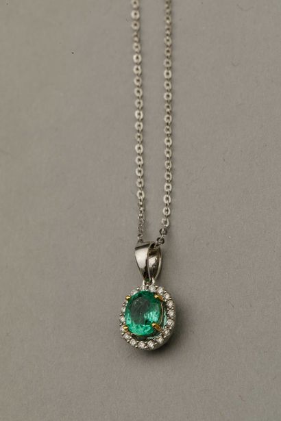 null Pendant in 18k white gold in the form of an openwork oval set with an emerald...