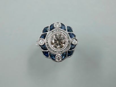null A platinum ring with a rosette motif centered on a diamond weighing approximately...