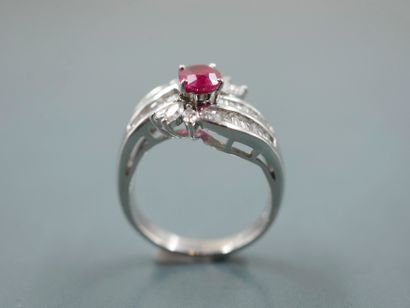 null 
A platinum ring set with a 1ct oval ruby surrounded by two lines of baguette-cut...