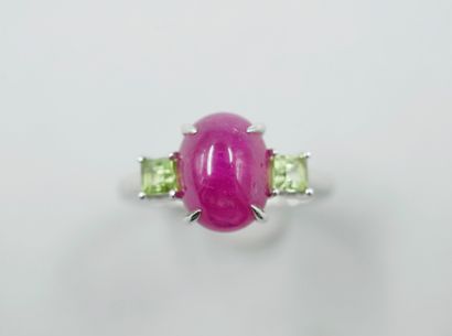 null 18k white gold ring set with a ruby cabochon of about 4cts and two peridots....
