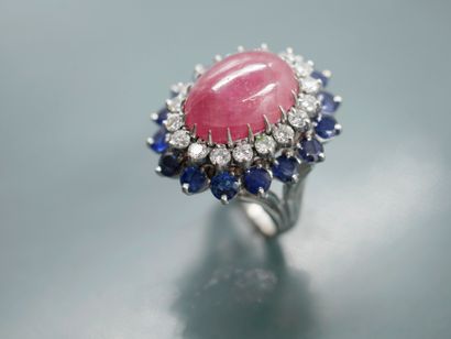 null 14k white gold pompadour ring set with a ruby cabochon surrounded by a line...