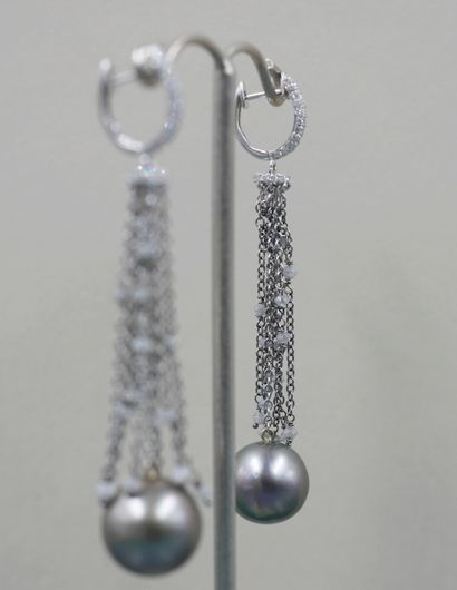 null Pair of 18k white gold earrings with diamond pendants and a line holding a 10mm...