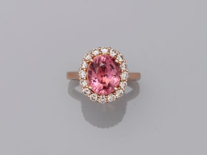 null 18k rose gold ring set with an oval pink tourmaline of 3.50cts circled by a...