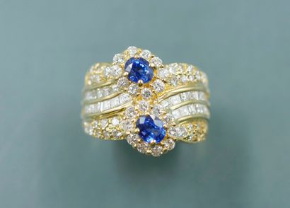 null 18k yellow gold band ring set with two oval sapphires in a diamond setting on...