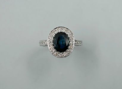 null 18k white gold ring set with a 2.50cts oval sapphire surrounded by a line of...